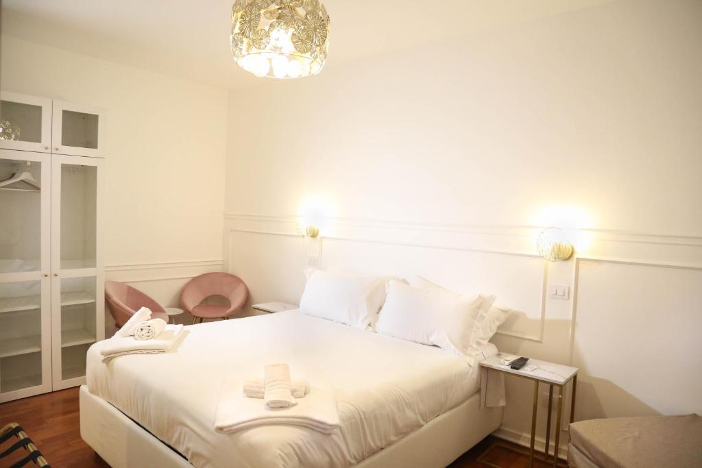 a bedroom with a white bed and a chandelier at Mama House Roma in Rome