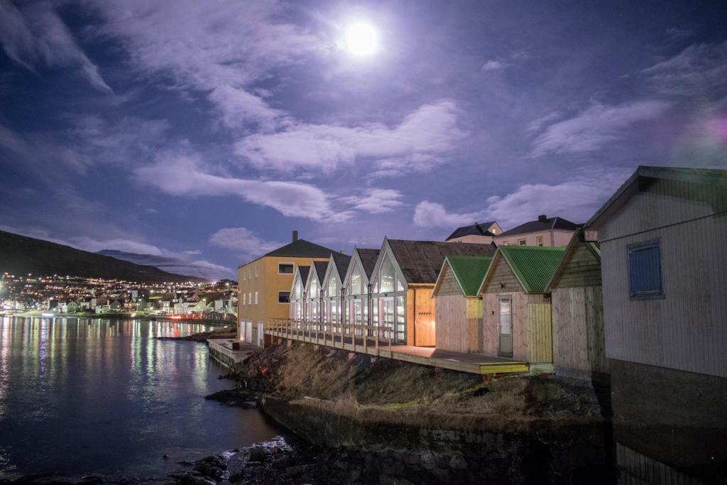 uma linha de edifícios ao lado de uma massa de água em Cottages by the Sea em Sørvágur