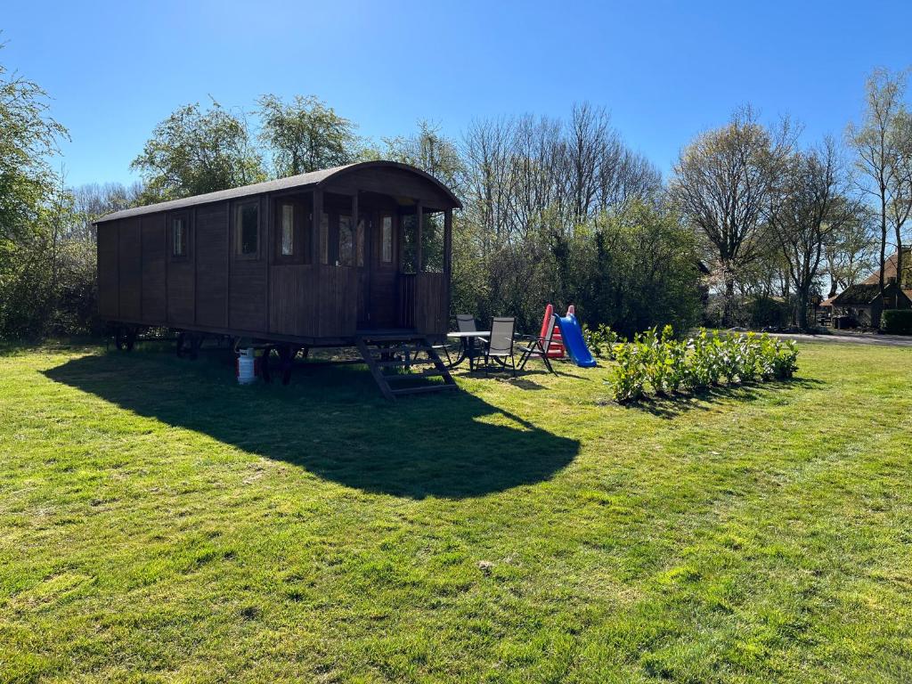 een kleine hut midden in een grasveld bij Pipowagen voor 4 personen in Diever