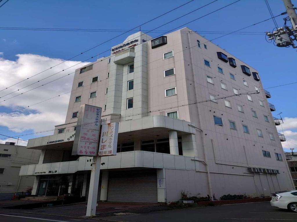 un gran edificio blanco en la esquina de una calle en Business Hotel Kawashima, en Wakayama