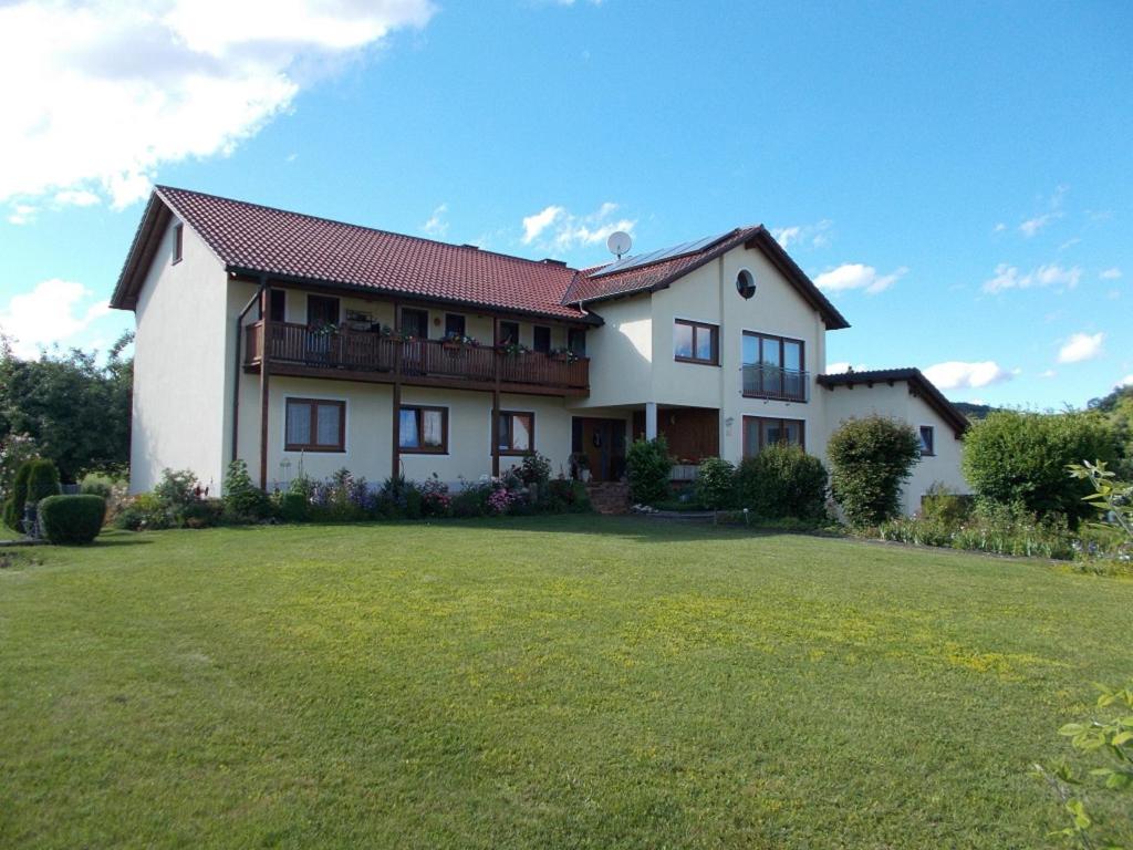 una grande casa bianca con un ampio cortile di Ferienwohnung Familie Bauer a Kelheim