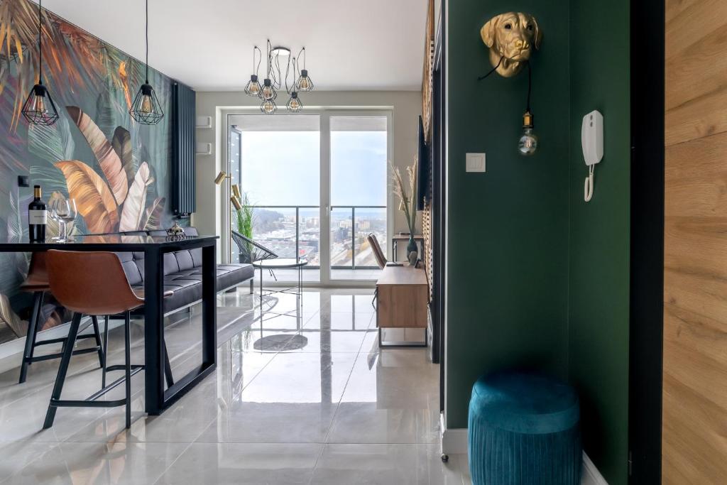 une salle à manger avec un mur vert et une table dans l'établissement Apartament 1612 Modern Tower Gdynia, à Gdynia