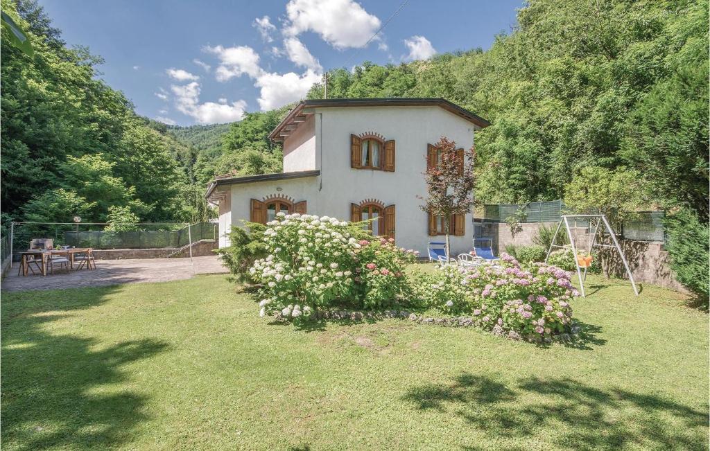 een klein wit huis met een tuin met bloemen bij Casa Ciricea in Piteccio