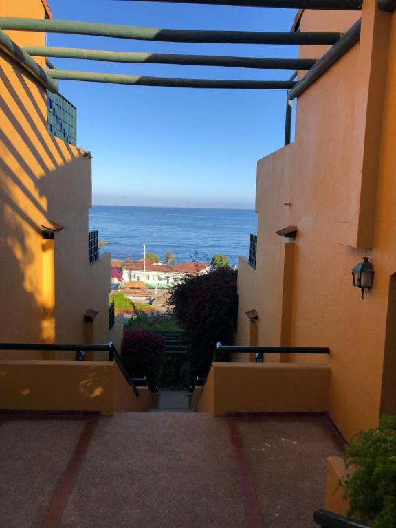 a view of the ocean from between two buildings at Departamento Algarrobo in Algarrobo