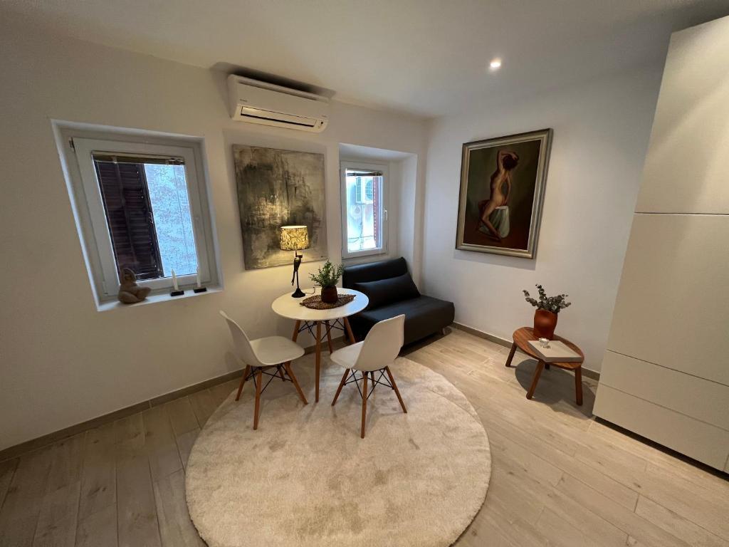 sala de estar con mesa, sillas y sofá en Noelle apartment, en Rovinj