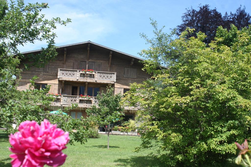 Résidence Chalet des Granges في ساموان: منزل مع شرفة وردة وردية