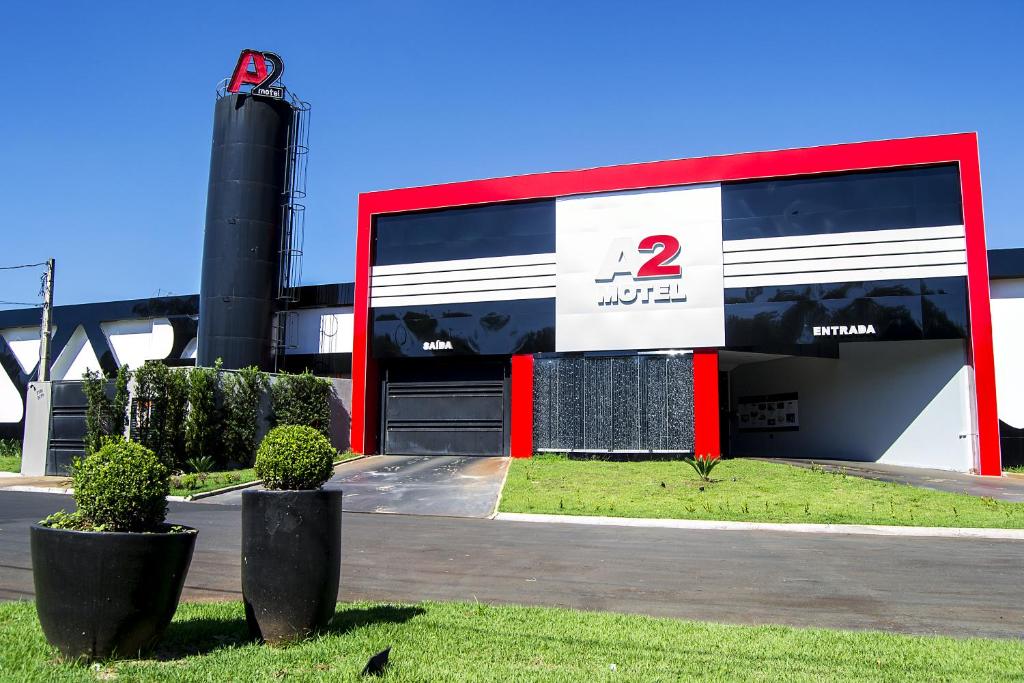 een tankstation met een rood-wit gebouw bij A2 Motel in Ribeirão Preto