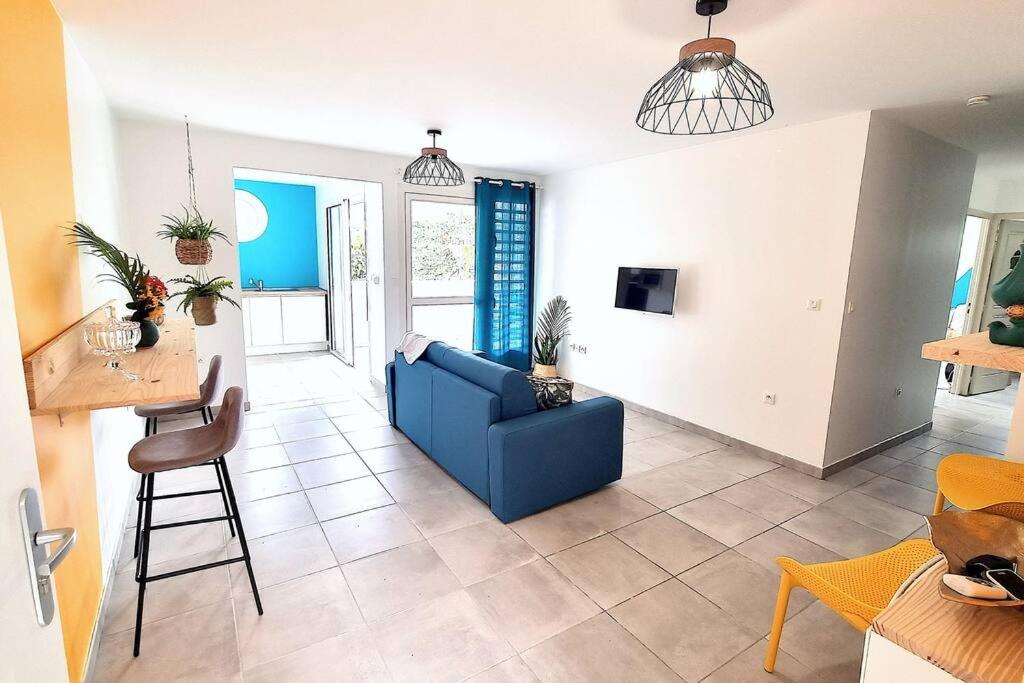 un soggiorno con divano blu e tavolo di Le Marie-Agnès Appartement neuf de Standing a Fort-de-France