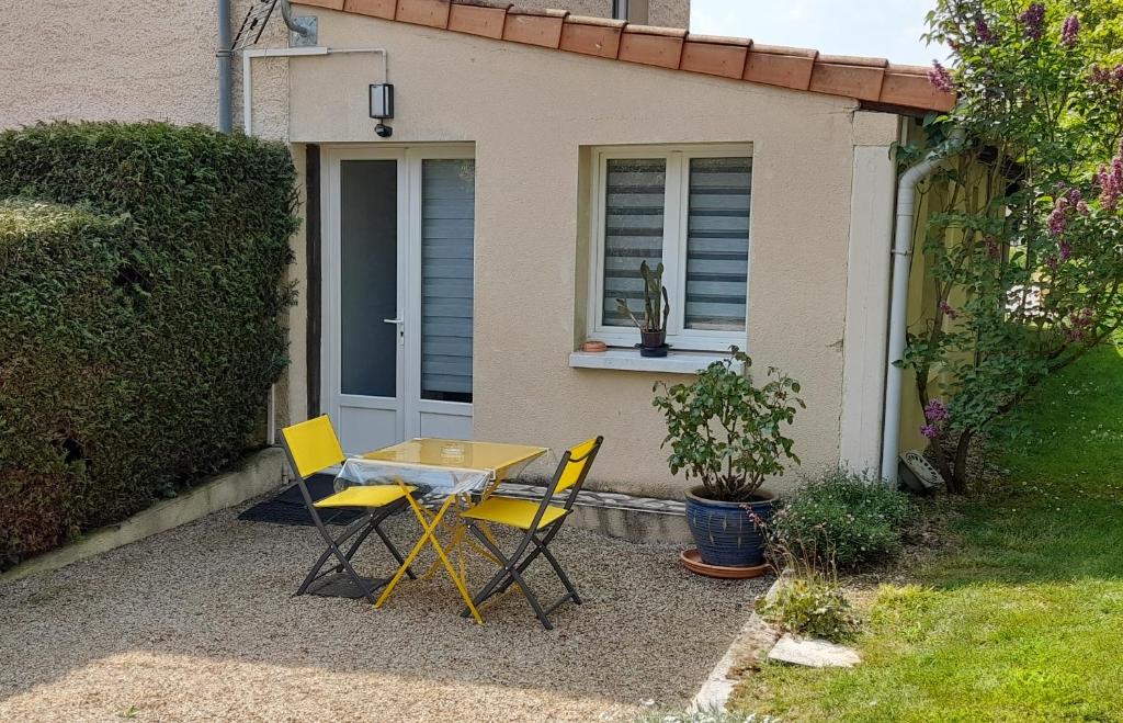 a table and chairs in front of a house at Le PATSA de Vouillé in Vouillé