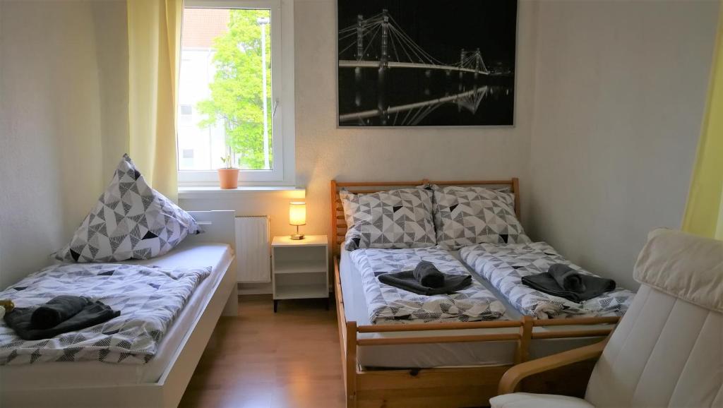 a bedroom with two beds and a window at Apartment am Südpark in Merseburg