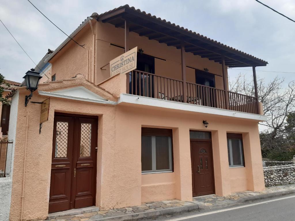 uma pequena casa com uma varanda em cima em Christina Guest House em Mystras