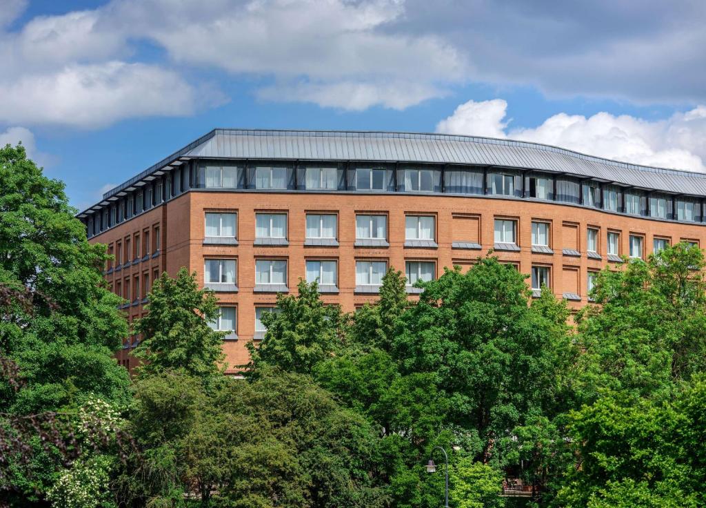 un bâtiment en briques avec des arbres devant lui dans l'établissement Dorint Hotel Bremen, à Brême