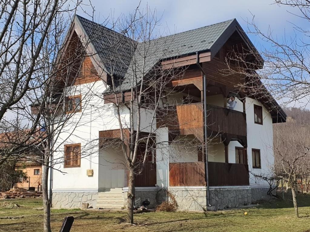 a white house with a gambrel roof at Livada lui Papu in Izvoarele