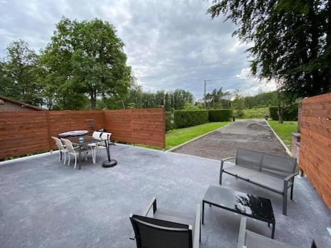 d'une terrasse avec une table, des chaises et une clôture. dans l'établissement GITE DE LA FAMENNE, à Marche-en-Famenne