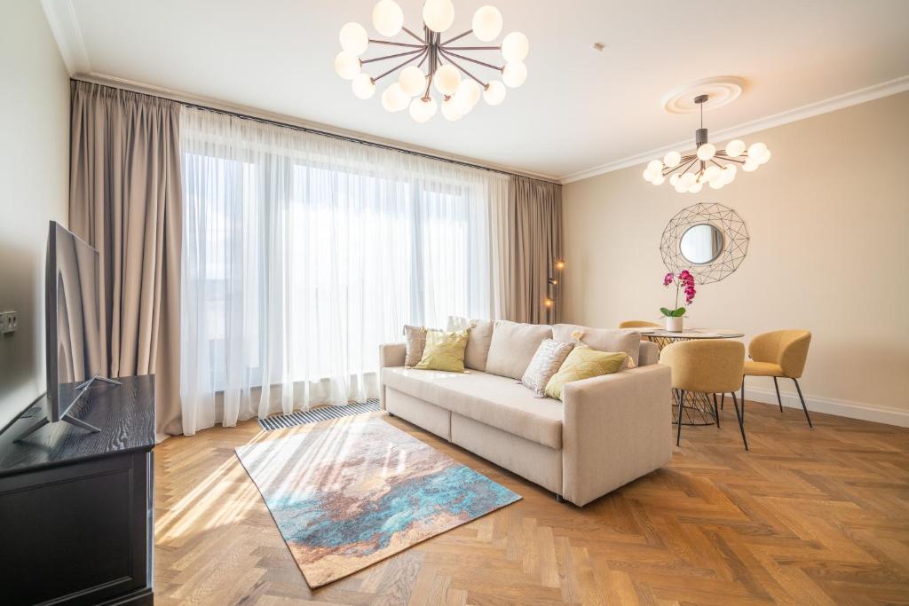 een woonkamer met een bank en een tafel bij Easyrooms Dzirnavu in Rīga