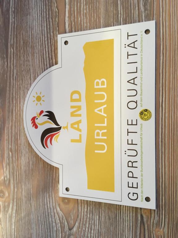 un cartello per un ristorante con un gallo sopra di Ferienwohnung Saaletalblick a Jena