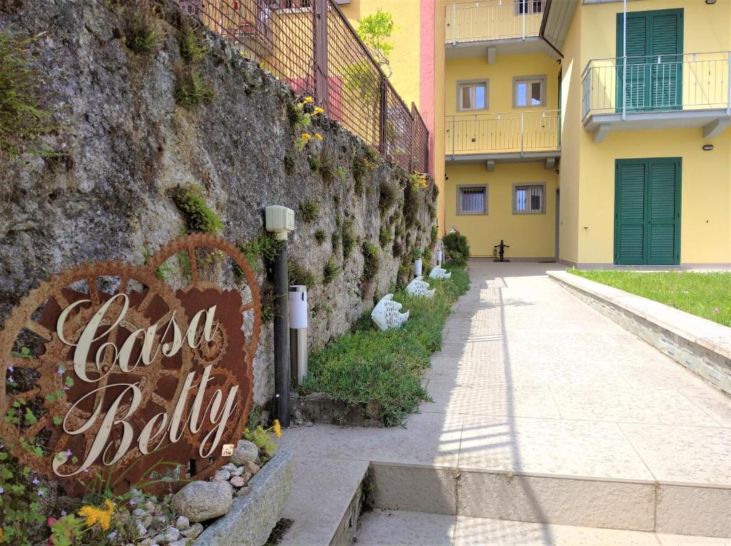 eine Wand mit einem Kokain-Baby-Schild neben einem Bürgersteig in der Unterkunft Casa Betty in Baveno