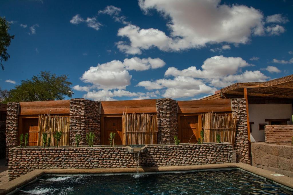 una casa con piscina frente a ella en Terrantai Lodge, en San Pedro de Atacama