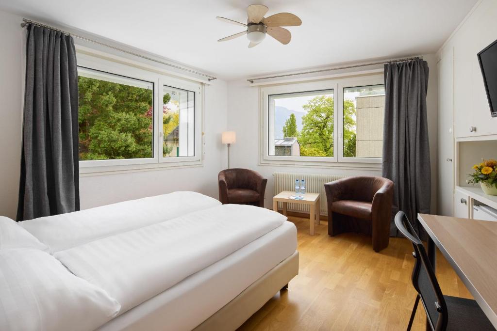 a hotel room with a bed and a table and chairs at Bon Port in Montreux