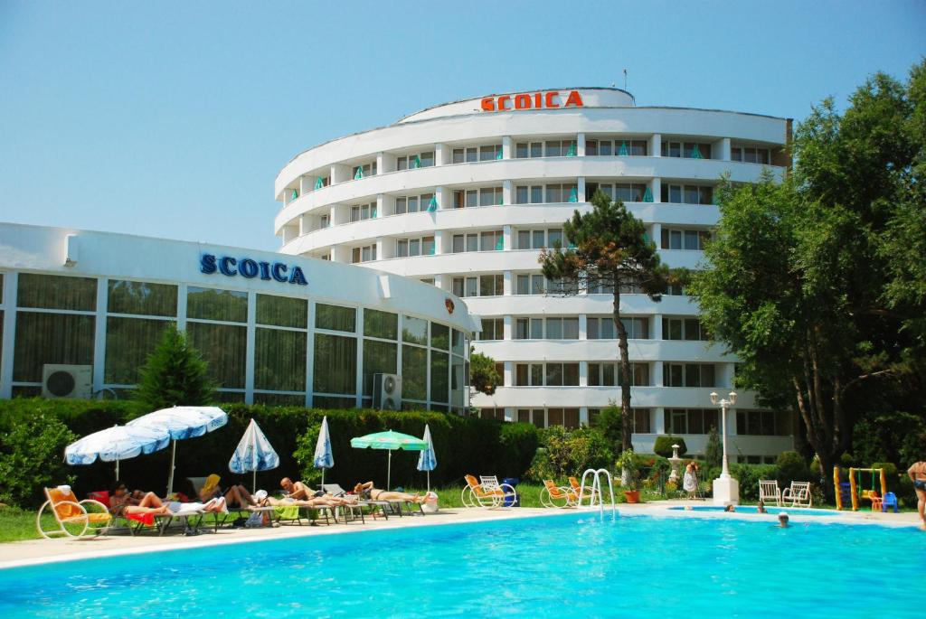 a hotel with a swimming pool in front of a building at Hotel Scoica in Jupiter