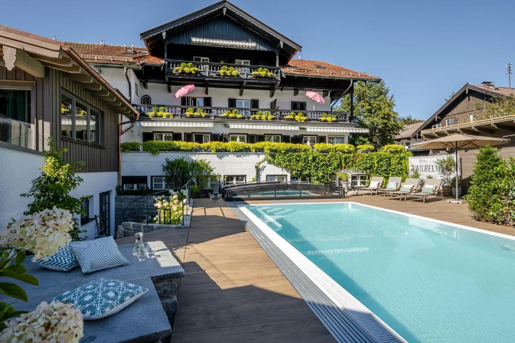 een hotel met een zwembad voor een gebouw bij Boutique Hotel Relais Chalet Wilhelmy in Bad Wiessee