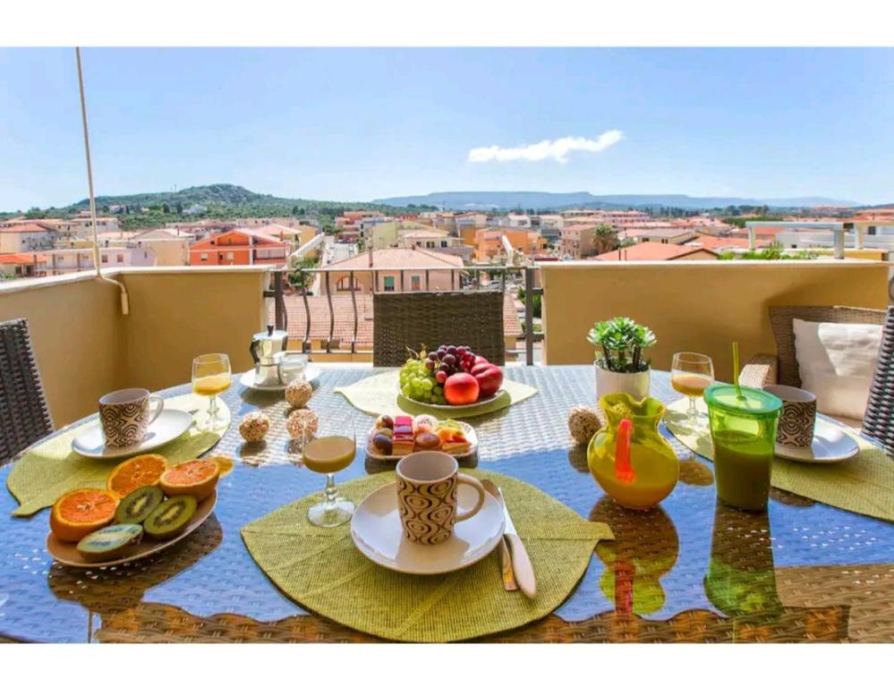 un tavolo con cibo e bevande su un balcone di Panorama ad Alghero