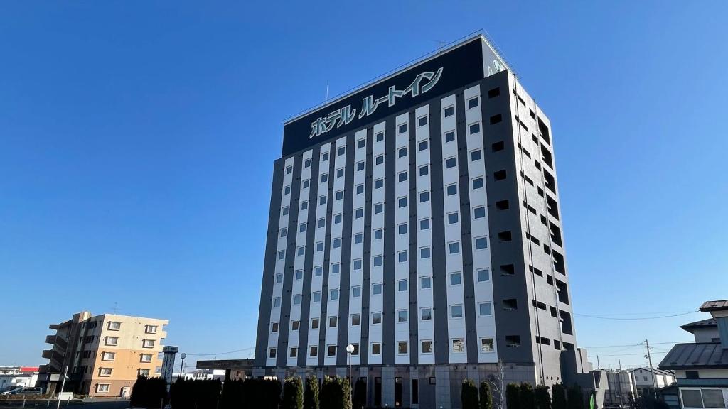 a building with a sign on the top of it at Hotel Route-Inn Ichinoseki Inter in Ichinoseki