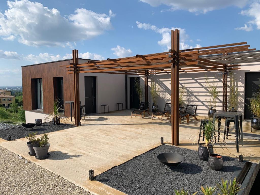 a patio with a wooden pergola and chairs at Le 7 in Vieille-Toulouse