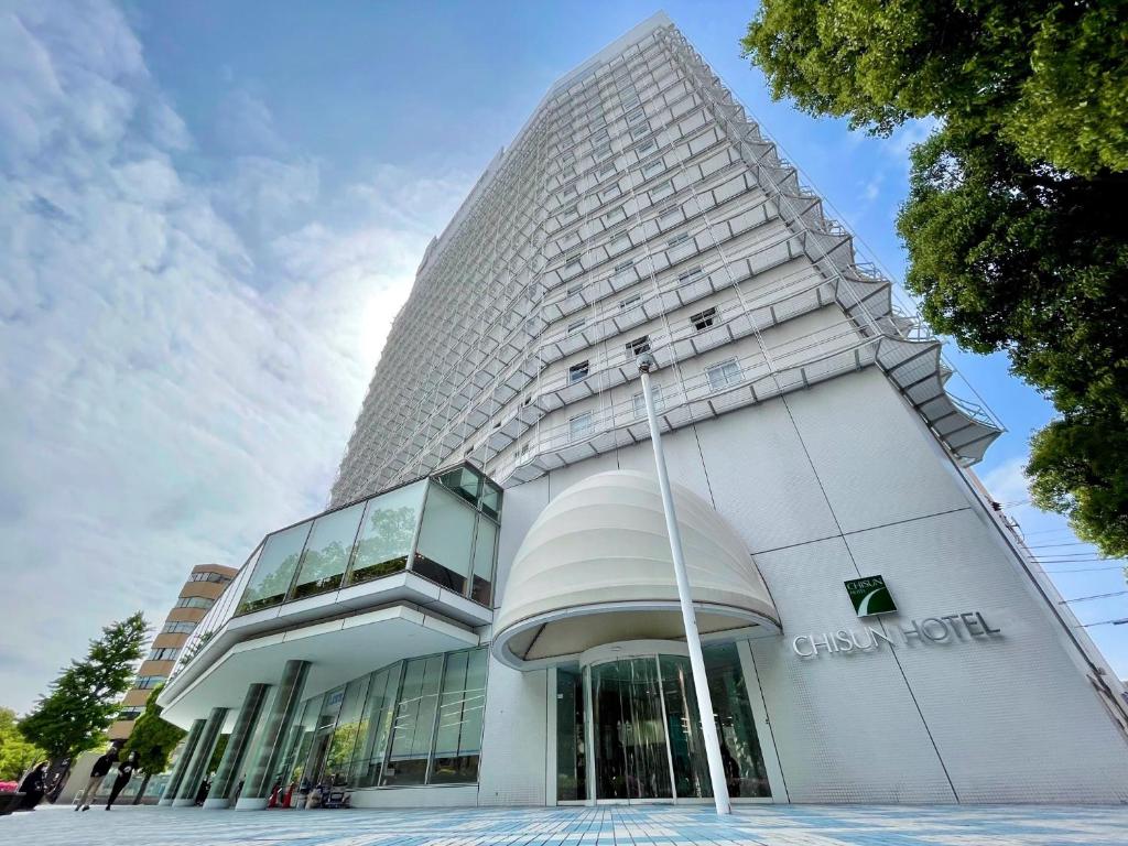 un alto edificio bianco con facciata in vetro di Chisun Hotel Yokohama Isezakicho a Yokohama