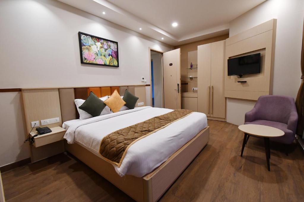 een hotelkamer met een bed en een televisie bij Soho Boutique Hotel in Mysore