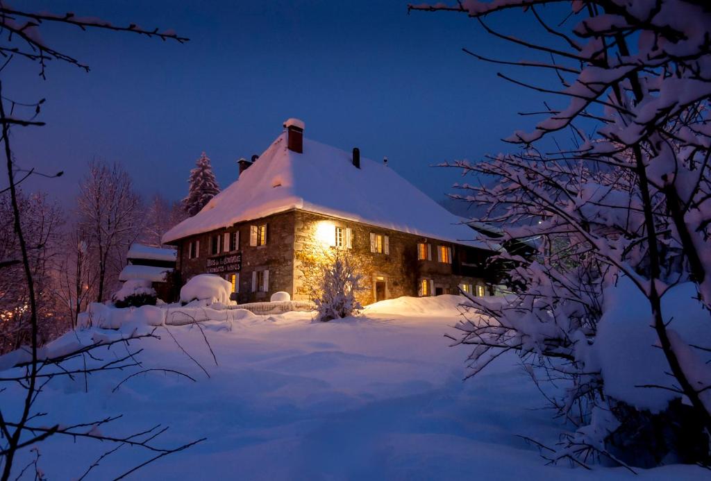 uma casa coberta de neve à noite em Hotel Mas de la Coutettaz, The Farmhouse em Morzine