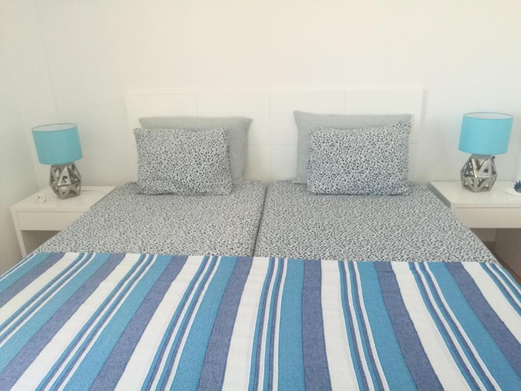 1 Schlafzimmer mit 2 Einzelbetten und blauen Kissen in der Unterkunft Casa ao Mar in Monte Gordo