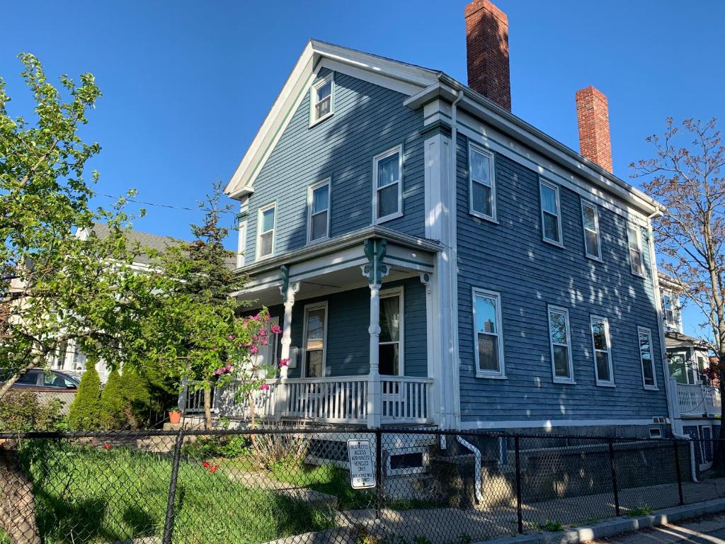 una casa blu con camino e recinzione di Beautiful Victorian house, Room a Boston