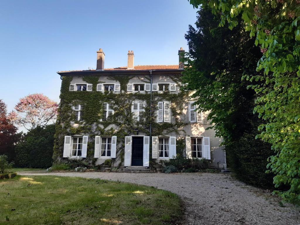 uma antiga casa de pedra com janelas brancas e uma entrada em Logis HOTEL DU PARC em Pont-à-Mousson