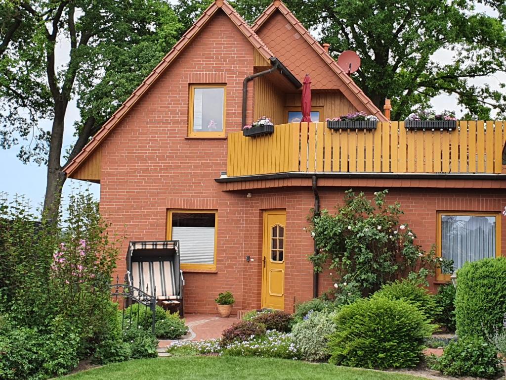 una casa in mattoni rossi con una porta gialla di Ferienwohnung Heike Heitmann a Eystrup