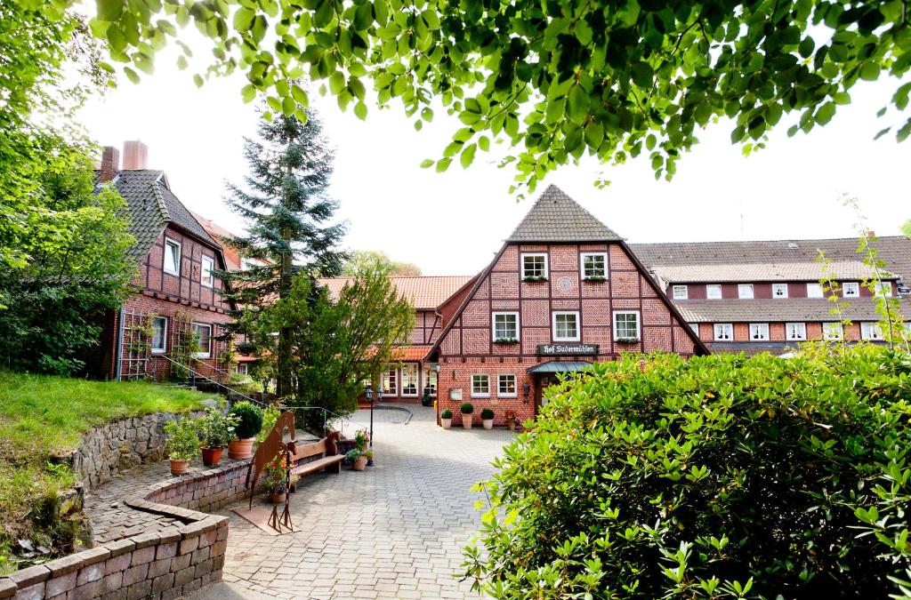 une femme debout devant un bâtiment dans l'établissement Hotel Hof Sudermühlen, à Egestorf