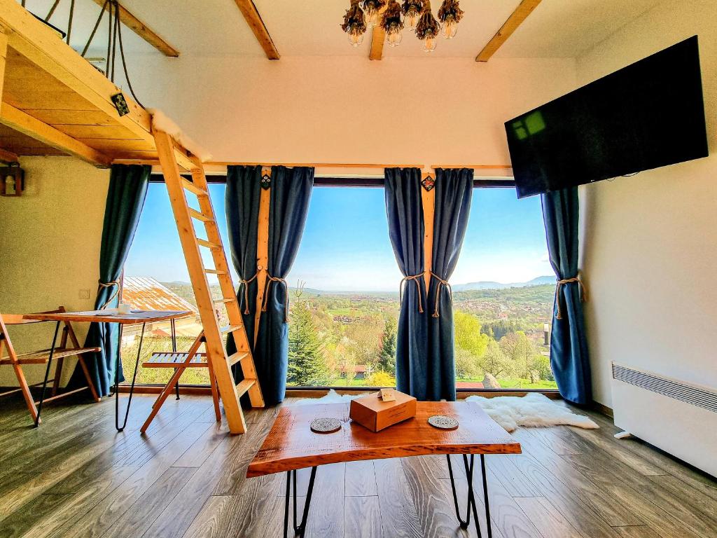 um quarto com uma cama alta e vista para uma montanha em Tiny House Retreat Bran em Bran