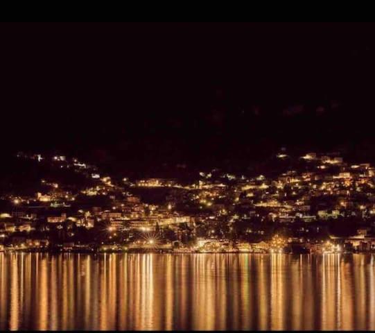 - une vue sur la ville la nuit avec l'eau dans l'établissement Little Suite Near Lake, à Verbania