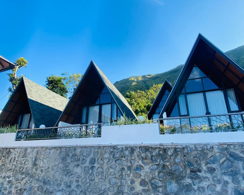 a house with triangular windows on a stone wall at Bukit Tiga Lima Boutique Hotel in Sajang