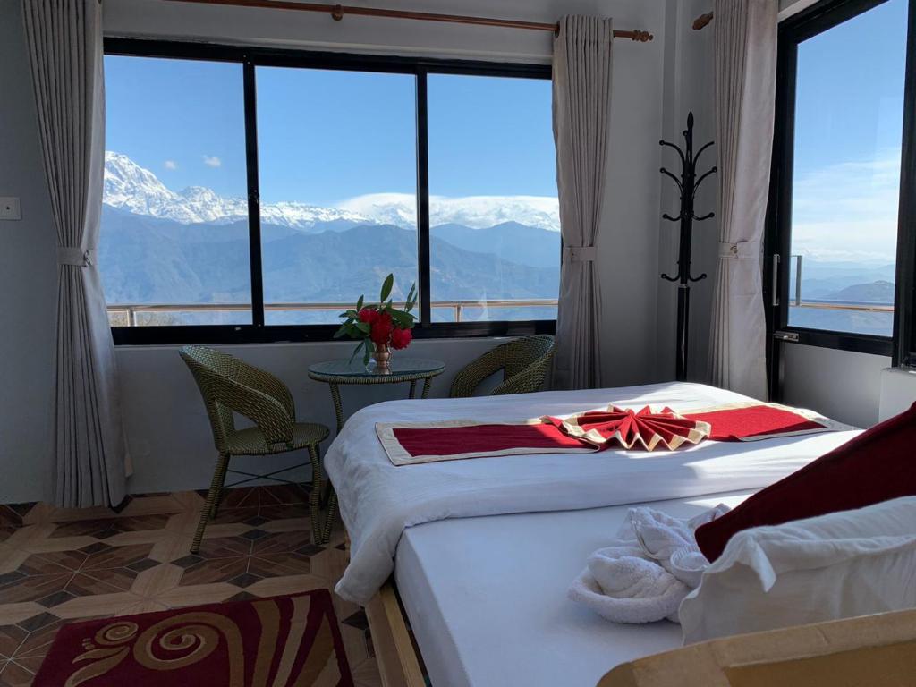 een hotelkamer met 2 bedden en uitzicht op de bergen bij Hotel Pristine Himalaya in Pokhara