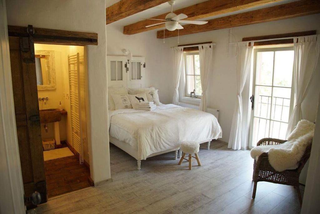 a bedroom with a white bed and a ceiling fan at Koňsky ap in Pouzdřany