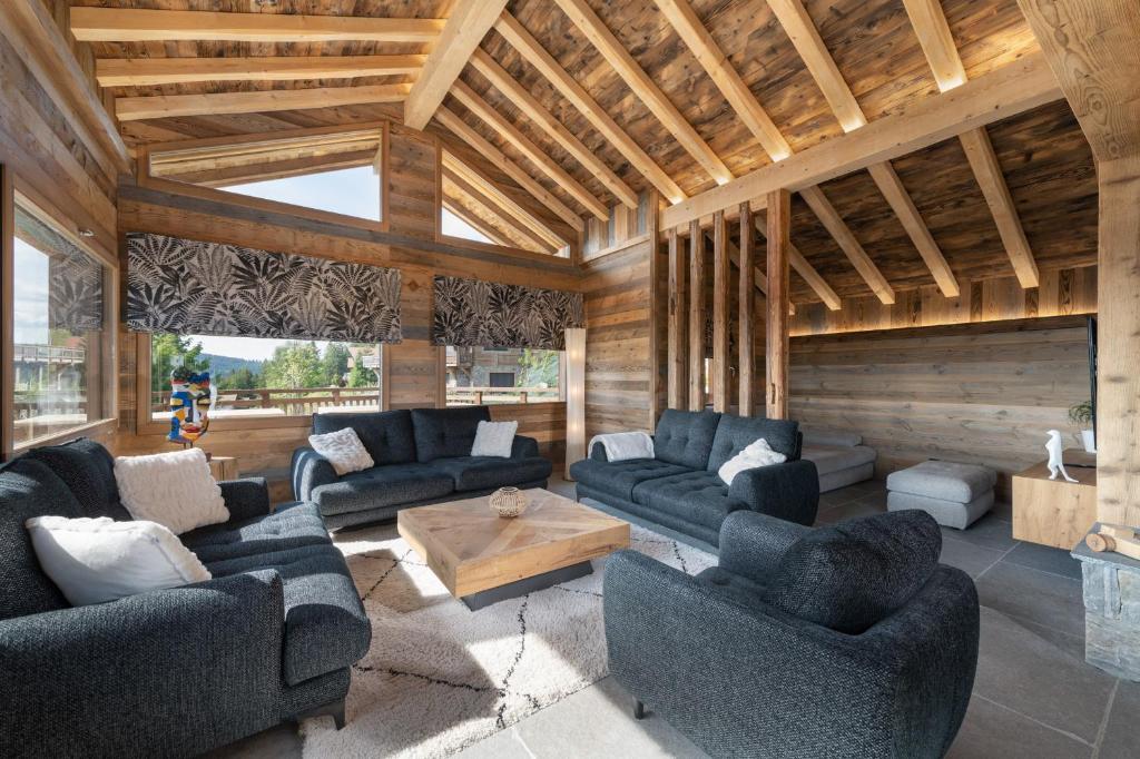 a living room with blue couches and a wooden ceiling at Aigle des Neiges 5 étoiles in Gérardmer