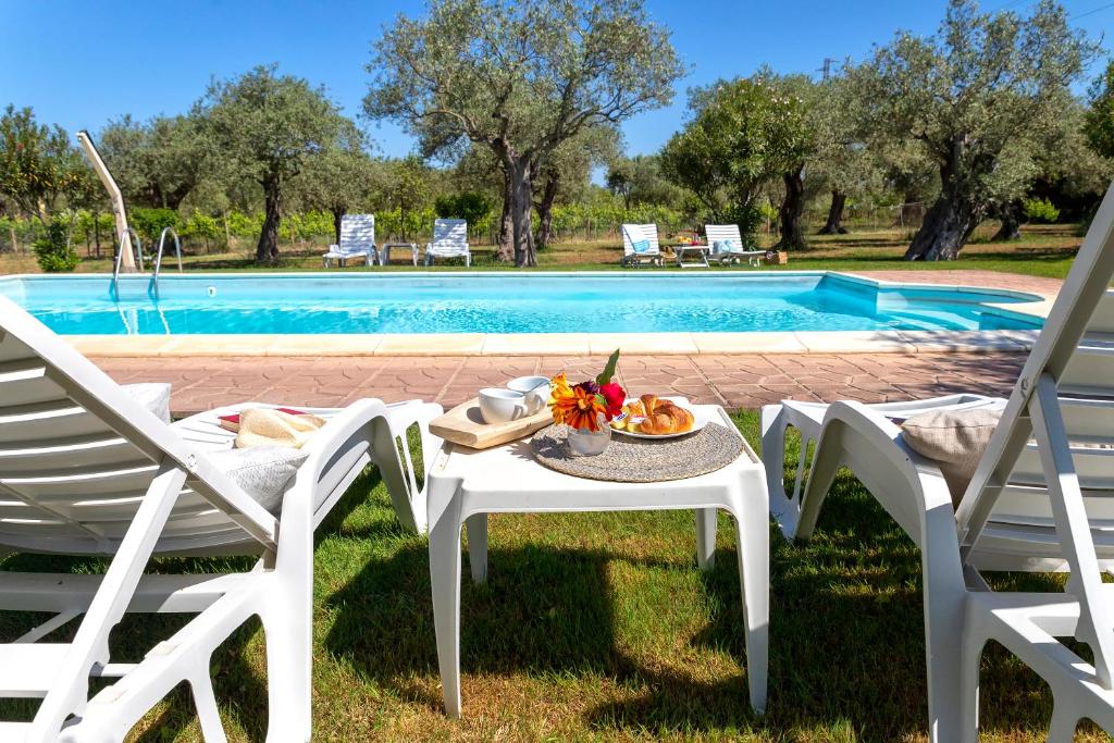 uma mesa e cadeiras ao lado de uma piscina em Villa Grazia em Alghero