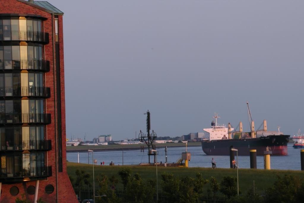 un gran barco en el agua junto a un edificio en NewPort Weser, NewPort Marina, en Bremerhaven