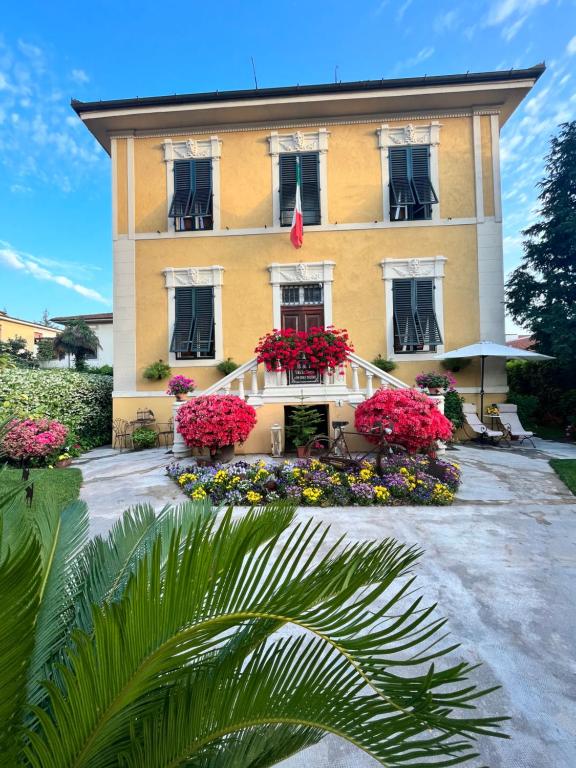 een geel gebouw met bloemen ervoor bij Villa San Donato B&B in Lucca