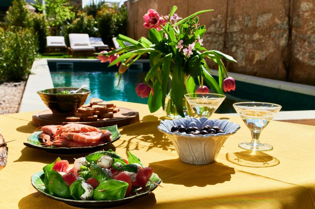 een tafel met borden eten op een tafel met een zwembad bij Vila Branca Guesthouse - Palacete in Figueira da Foz