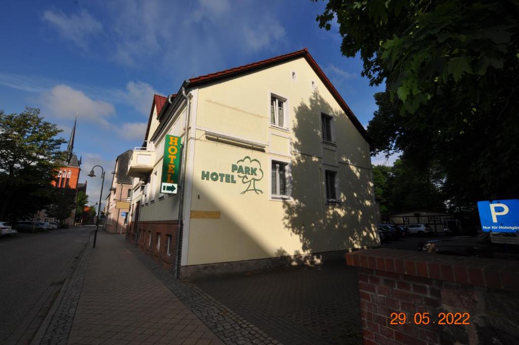 a white building with a sign on the side of it at Parkhotel Schwedt in Schwedt