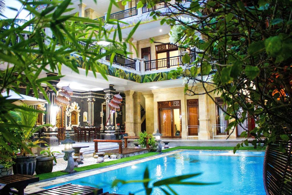 a pool in the middle of a building with trees at Bali 85 Beach Inn in Padangbai