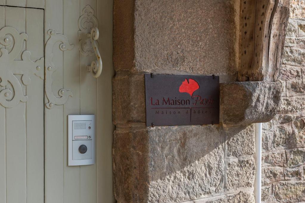 a sign on the side of a stone building at La Maison Pavie in Dinan