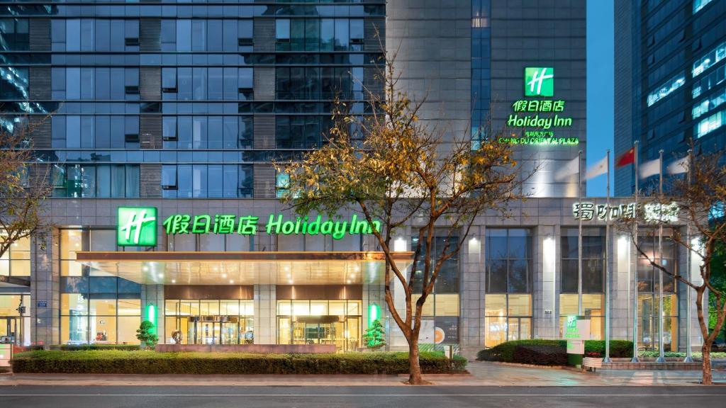 un edificio con cartelli verdi sulla parte anteriore di Holiday Inn Chengdu Oriental Plaza, an IHG Hotel a Chengdu